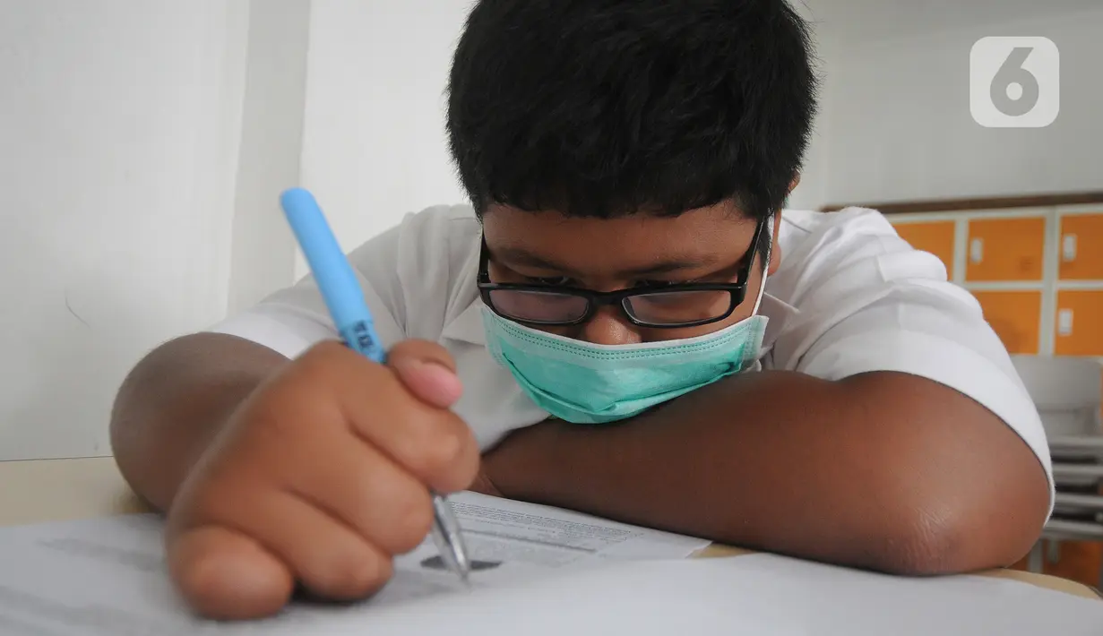 Seorang murid mengerjakan soal saat kegiatan KSN seleksi Tingkat SD/ MI Kecamatan Cinere  mata pelajaran IPA di SDIT MU, Depok, Jawa Barat, Sabtu (6/3/2021). Pelaksanaan KSN tahun ini dilaksanakan secara tatap muka dengan menerapkan protokol kesehatan. (merdeka.com/Arie Basuki)