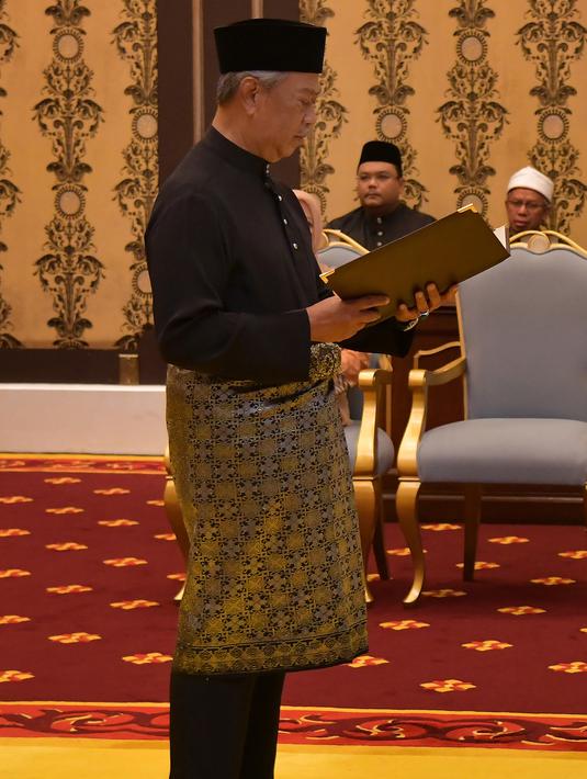 Muhyiddin Yassin menyatakan sumpah saat upacara pelantikannya sebagai Perdana Menteri Malaysia di Istana Negara, Kuala Lumpur, Minggu (1/3/2020). Raja Sultan Abdullah Sultan Ahmad Shah menunjuk langsung Muhyiddin sebagai PM Malaysia. (MASZUANDI ADNAN/MALAYSIA'S DEPARTMENT OF INFORMATION/AFP)