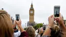 Sejumlah orang menggunakan ponsel merekam dentang terakhir Big Ben di Elizabeth Tower, London, Senin (21/8). Menara jam tersebut berhenti berdentang hingga empat tahun mendatang untuk renovasi besar-besaran di Gedung Parlemen. (AP Photo/Frank Augstein)