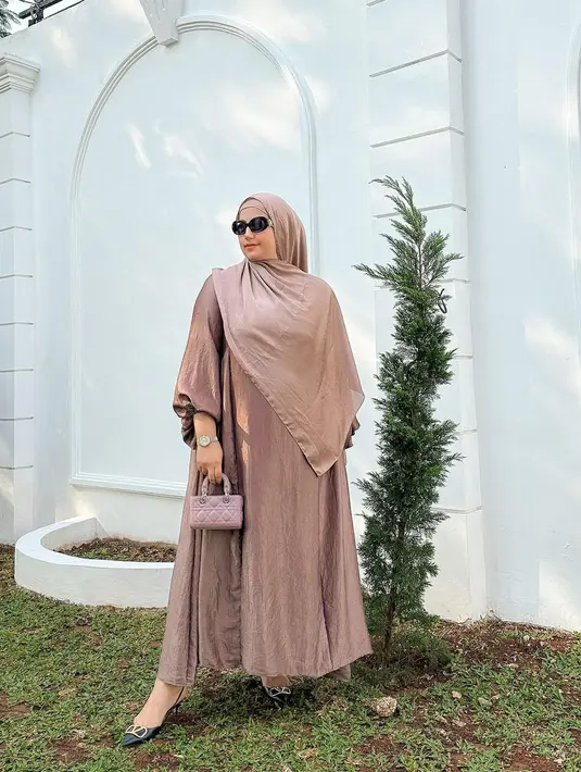 Ia memadukan gamis cokelat, yang kemudian dipadukannya dengan hijab cokelat senada yang sama-sama polos. [Foto: Instagram/tasyiiathasyia]