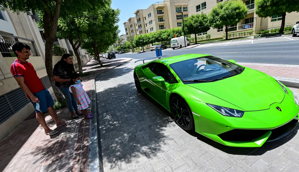 Direktur Pelaksana Pakistan Supermarket Dubai Muhammad Jehanzeb mengendarai Lamborghini Huracan usai mengirim pesanan mangga di Dubai, Uni Emirat Arab, Kamis (2/7/2020). Supermarket tersebut mengantarkan pesanan mangga untuk minimal pesanan sekitar USD 27. (CACACE GIUSEPPE/AFP)