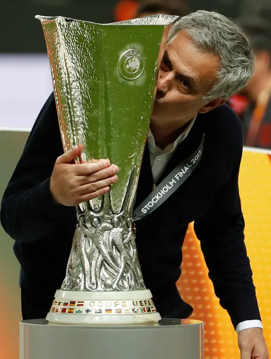 Jose Mourinho mencium trofi usai pertandingan melawan Ajax Amsterdam pada final Liga Europa di Friends Arena pada 24 Mei 2017. MU menang 2-0 atas Ajax berkat gol Pogba dan Henrikh Mkhitaryan. (AFP Photo/Odd Andersen)