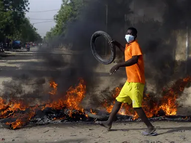 Seorang anak laki-laki protes di N'Djamena, Chad, Selasa (27/4/2021). Ribuan orang melakukan protes dan dua orang tewas dalam demonstrasi menentang aturan dewan militer transisi yang dipimpin putra Presiden Idriss Deby Itno yang terbunuh minggu lalu. (AP Photo/Sunday Alamba)