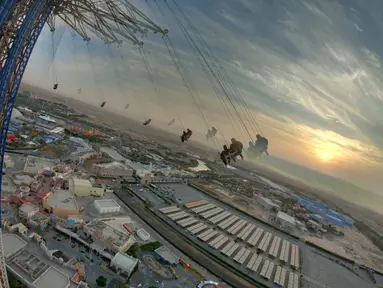Orang-orang menaiki sky flyer di Taman Bollywood di Dubai (18/2/2021). Menjulang hingga 140 meter, Sky Flyer di Taman Bollywood, Dubai, memecahkan rekor dunia sebagai ayunan tertinggi dunia. (AFP/ Giuseppe Cacae)