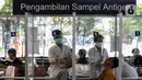 Calon penumpang saat menjalani tes antigen di Stasiun Pasar Senen, Jakarta, Senin (20/12/2021). Pelanggan yang tidak menerapkan protokol kesehatan sesuai ketentuan yang telah ditetapkan, tiketnya akan dibatalkan dan tidak diperkenankan melanjutkan perjalanan. (Liputan6.com/Johan Tallo)