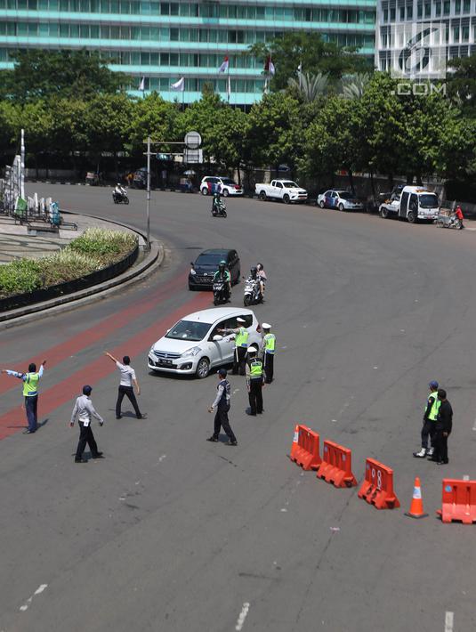 Petugas melakukan rekayasa lalu lintas imbas dari kegiatan May Day 2018 di kawasan Harmoni, Jakarta Pusat, Selasa (1/5). Berdasarkan data kepolisian, ada sekitar 30 ribu buruh akan ke Jakarta. (Liputan6.com/Arya Manggala)