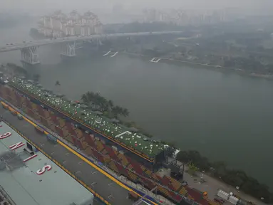 Pandangan dari atas Sirkuit Marina Bay Street yang tertutup asap tebal, Singapura, Rabu (16/9/2015). Kabut asap yang menyelimuti sirkuit tak menyurutkan penyelenggara untuk tetap melangsungkan F1 Grand Prix Singapura. (REUTERS/Edgar Su)