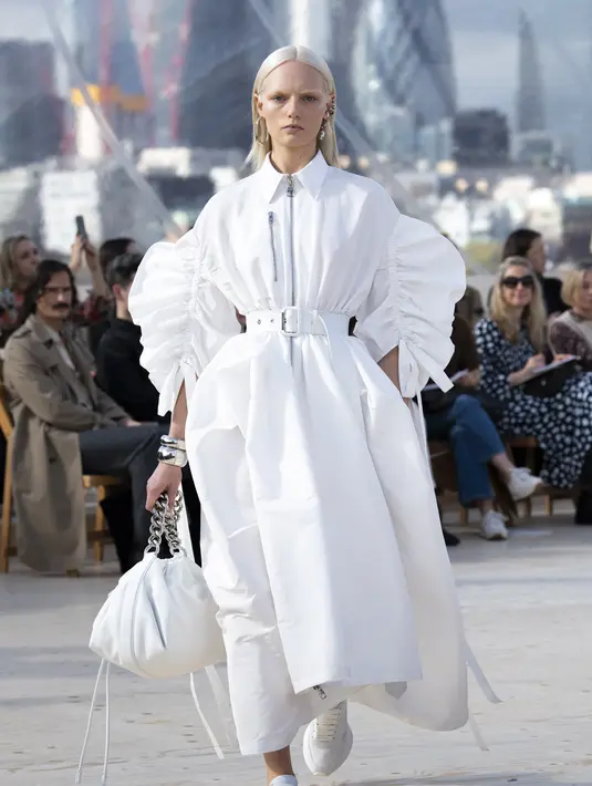 Shirt dress dengan detail ritsleting di bagian tengah memiliki lengan parasut berlipit dan rok parasut, dirancang dari bahan polu faille putih. Foto: Document/Alexander McQueen.
