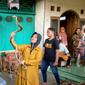 Iin Ayu (55) bermain dengan ular kobra di halaman rumahnya di Kelurahan Karangpucung, Purwokerto Selatan, Kabupaten Banyumas, Rabu (17/12) (Liputan6.com/Rudal Afgani Dirgantara)