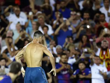 Aksi bintang Real Madrid, Cristiano Ronaldo melepas jersey usai mencetak gol ke gawang Barcelona pada laga Supercup Spanyol di Camp Nou stadium, Barcelona, (13/8/2017). (AP/Manu Fernandez)