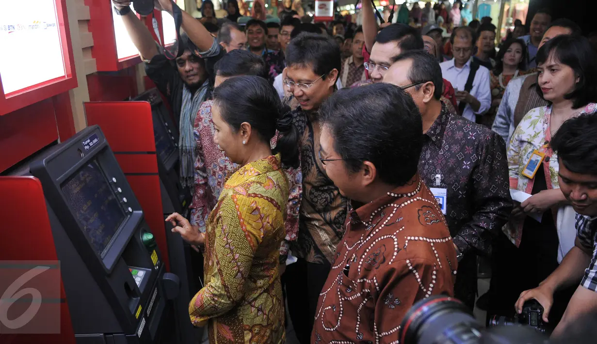 Menteri BUMN Rini Soemarno saat menjajal mesin ATM Himbara Link di pasar Tanah Abang, Jakarta, Senin (21/12). Empat bank BUMN yang tergabung dalam Himpunan Bank Milik Negara (Himbara) resmi meluncurkan fasilitas ATM Himbara. (Liputan6.com/Johan Tallo) 