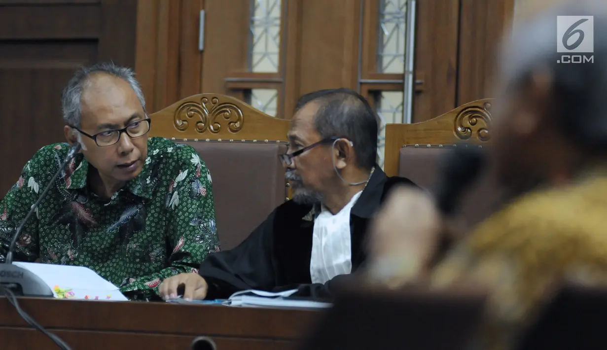 Terdakwa perkara merintangi penyidikan dugaan korupsi E-KTP, Bimanesh Sutarjo (kiri) berbincang dengan penasehat hukumnya saat mengikuti sidang lanjutan di Pengadilan Tipikor, Jakarta, Senin (23/4). (Liputan6.com/Helmi Fithriansyah)