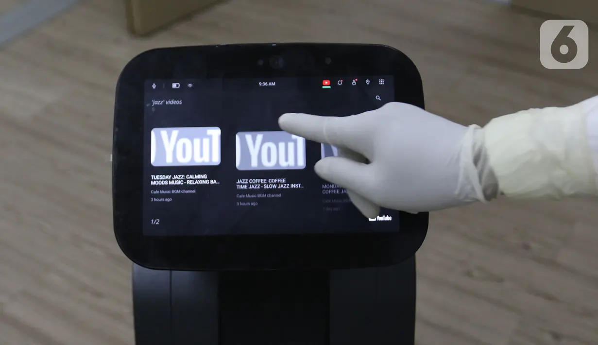 Perawat sedang menyetel lagu di robot temi saat di  kamar pasein  RSPJ Modular, Jakarta, Selasa (28/7/2020). Teknologi dengan robot, membantu tenaga medis dalam tanganin pasien Covid-19, salah satunya dapat berkonsultasi dengan dokter via Video Call. (Liputan6.com/Herman Zakharia)