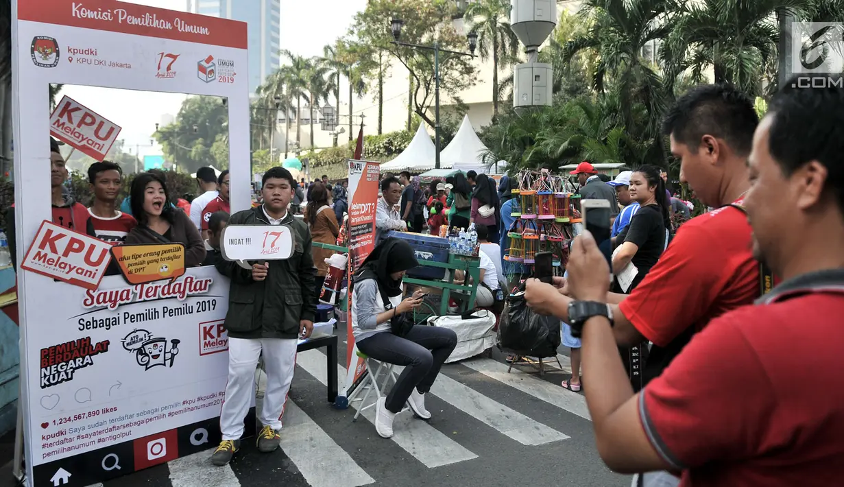 Warga berfoto di booth pos pendaftaran daftar pemilih tetap (DPT) di kawasan Car Free Day, Jakarta, Minggu (21/10). Komisi Pemilihan Umum (KPU) DKI Jakarta membuat pos pendaftaran untuk mendekatkan diri ke masyarakat. (Merdeka.com/Iqbal S. Nugroho)