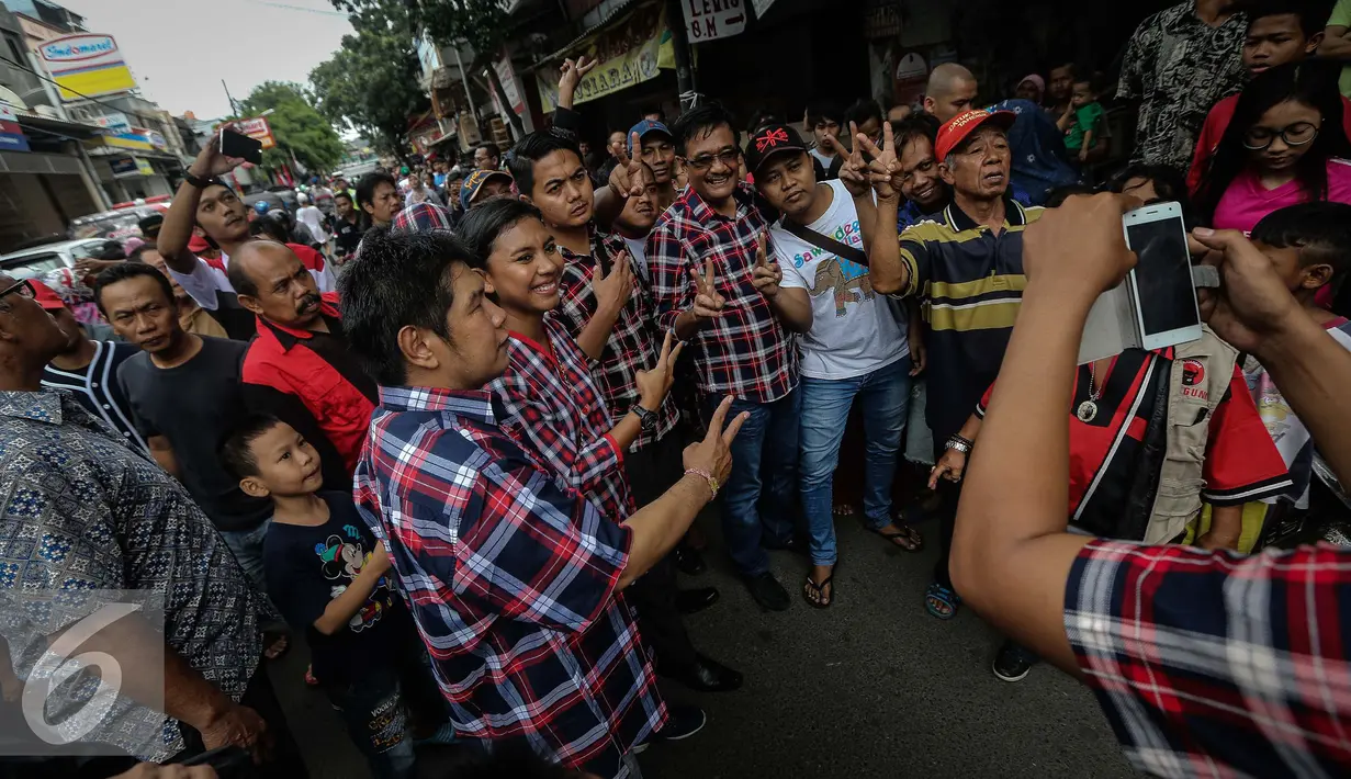 Djarot Saiful Hidayat berfoto bersama saat memberikan pengobatan gratis kepada warga RW 07, Jembatan Besi, Jakarta (15/1). Kegitaan itu dilakukan sebulan sekali berkeliling untuk meringankan beban warga yang kurang mampu. (Liputan6.com/Faizal Fanani)