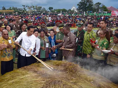 Presiden Joko Widodo dan Ibu Negara saat mengikuti ‎upacara Bakar Batu bersama masyarakat Pegunungan Tengah Papua di Stadion Mini Pendidikan, Distrik Wamena, Kabupaten Jayawijaya‎, Rabu (30/12). (Rumgapres)