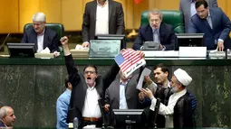 Suasana saat anggota parlemen Iran membakar dua lembar kertas bergambar bendera AS, Teheran, Iran, Rabu (9/5). Anggota parlemen Iran juga meneriakkan kalimat "Kematian untuk Amerika". (AP Photo)