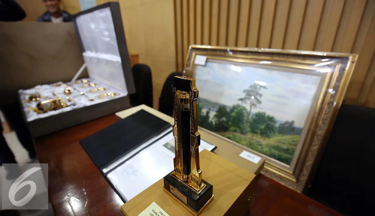 Plakat yang diduga barang gratifikasi yang diberikan kepada Presiden Jokowi seusai kunjungan kerja ke perusahaan minyak asal Rusia, Rosneft Oil Company 19-20 Mei lalu di di Gedung KPK, Jakarta, Jumat (28/10). (Liputan6.com/Helmi Affandi)