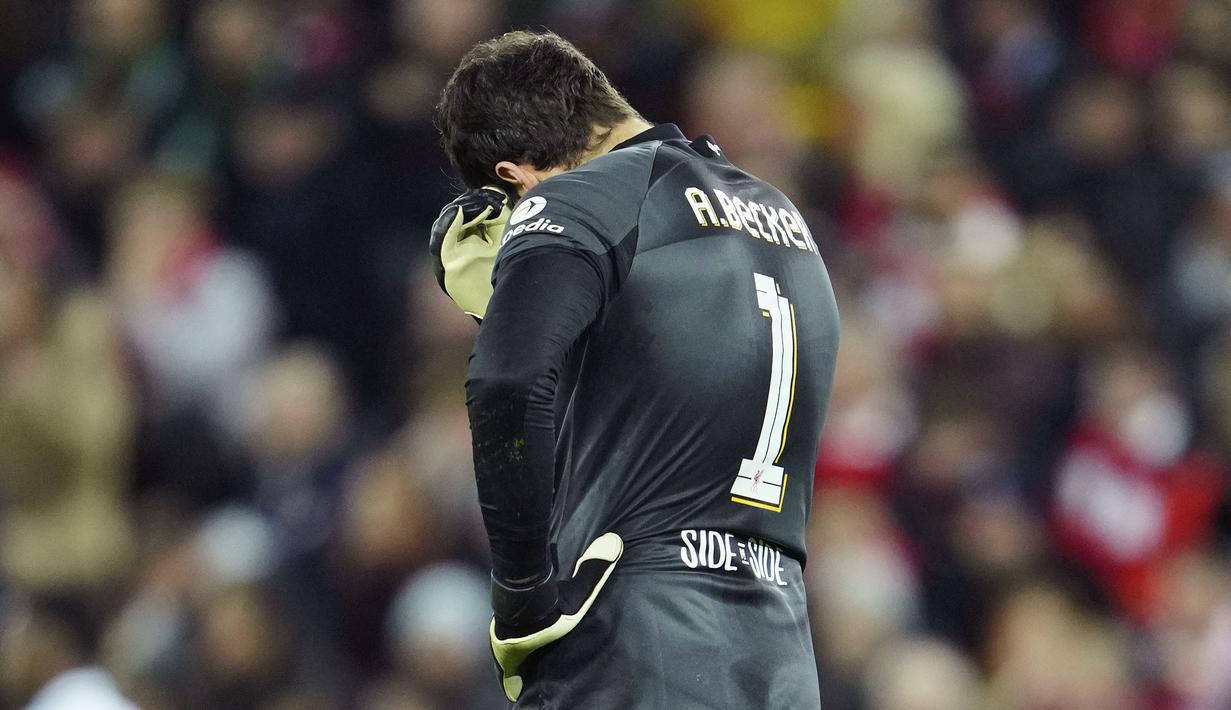 Reaksi kecewa kiper Liverpool, Alisson Becker setelah melakukan blunder saat laga leg pertama Liga Champions 2022/2023 melawan Real Madrid yang berlangsung di Anfield, Rabu (22/02/2023) WIB. Liverpool kalah dengan skor 2-5 dari Real Madrid. (AP Photo/Jon Super)