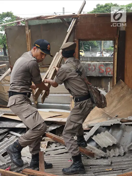 Petugas Satpol PP membongkar bangunan liar di Jalan Desa Semanan, Kalideres, Jakarta Barat, Senin (9/4). Nantinya kawasan tersebut akan digunakan untuk pembangunan taman. (Liputan6.com/Arya Manggala)