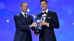 Penyerang Bayern Munchen, Robert Lewandowski menerima penghargaan Pemain Terbaik UEFA dari Presiden UEA Aleksander Ceferin dalam acara UEFA Awards di Genewa, Swiss (1/10/2020). (Harold Cunningham / AFP / UEFA)