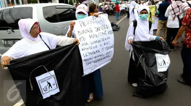 Sejumlah relawan membawa kantong plastik besar dan spanduk bertuliskan "Throw A HOAX, Here Please" di tengah aksi damai 4 November di Jakarta, Jumat (4/11). Mereka mengumpulkan sampah yang dibuang anggota ormas. (Liputan6.com/Faizal Fanani)