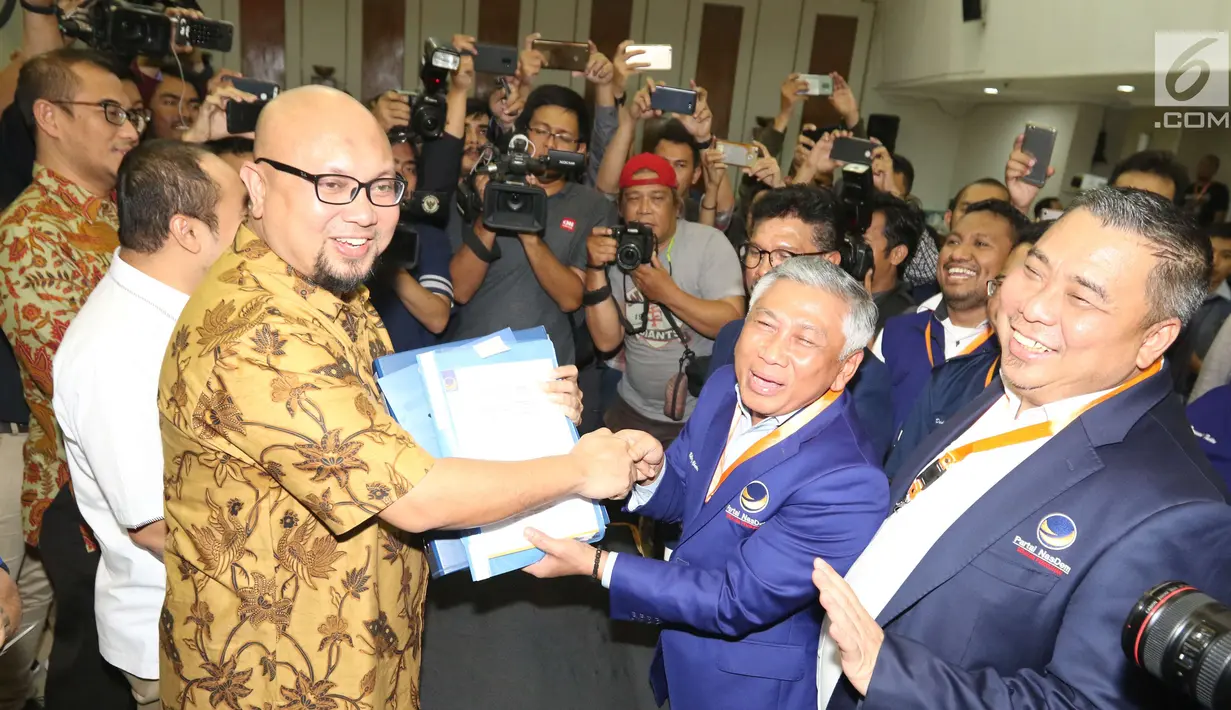Ketua Bapilu NasDem, Effendy Choirie menyerahkan berkas pendaftaran kepada ke anggota Komisi Pemilihan Umum (KPU) RI di Jakarta, Senin (16/7). NasDem secara resmi mendaftarkan bakal calon anggota DPR RI untuk Pemilu 2019 ke KPU (Liputan6.com/Angga Yuniar)