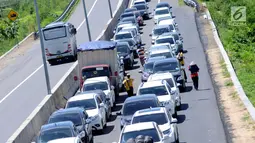 Pedagang menjajakan makanan ke pengendara jelang Simpang Tiga Keluar Tol Brebes, Jateng, Sabtu (23/12). Memanfaatkan kepadatan arus libur panjang Natal 2017, pedagang menjajakan dagangan di Simpang Tiga Keluar Tol Brebes. (Liputan6.com/Helmi Fithriansyah)