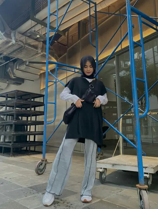 Cocok buat hangout, padu padan oversized knit vest warna hitam, kemeja putih, dan cullot jeans tak kalah menarik. Simpel tapi stylish! (Instagram/aishaibrahimmm).