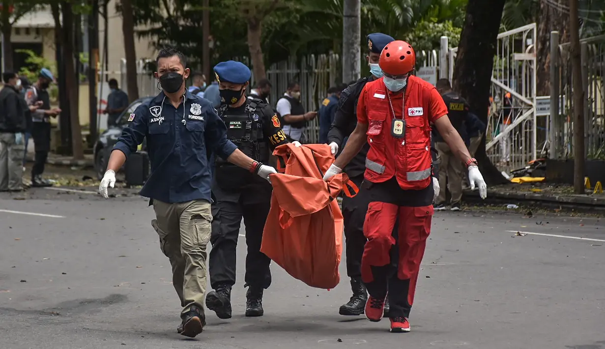 Polisi membawa tas berisi sisa-sisa tubuh tersangka pelaku bom bunuh diri setelah ledakan di luar sebuah gereja di Makassar (28/3/2021). Ledakan terjadi di Gerbang Gereja Katedral Makassar pada Minggu (28/3/2021). (AFP/Indra Abriyanto)