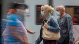 Penumpang berjalan di sepanjang peron di stasiun kereta utama di Frankfurt, Jerman, Jumat (14/8/2020). Mengenakan masker untuk melindungi diri dari corona Covid-19 adalah kewajiban di transportasi umum di Jerman. (AP Photo/Michael Probst)