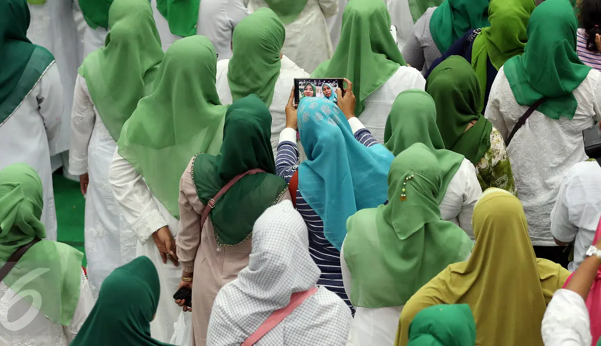 Umat muslim saat berselfie saat acara Silaturahmi Nasional Ulama Rakyat di Ancol, Jakarta, Sabtu (12/11). Acara yang di gagas oleh Partai Kebangkitan Bangsa tersebut bertujuan mendoakan keselamatan Bangsa Indonesia. (Liputan6.com/Johan Tallo)
