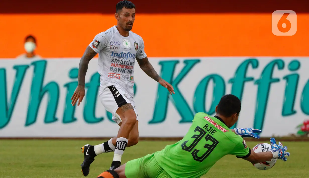 Kiper Persiraja Banda Aceh, Aji Bayu Putra (kanan) berhasil menangkap bola tendangan dari pemain Bali United, Stefano Lilipaly dalam pertandingan Babak Penyisihan Grup D Piala Menpora 2021 di Stadion Maguwoharjo, Sleman, Senin (29/3/2021). Bali United menang 2-0. (Bola.com/Ikhwan Yanuar)