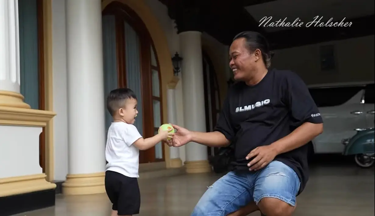 Komedian dan pembawa acara itu tampak bahagia melihat putranya datang. Sule kemudian mengajak mainan bola. [Youtube/NATHALIE HOLSCHER]