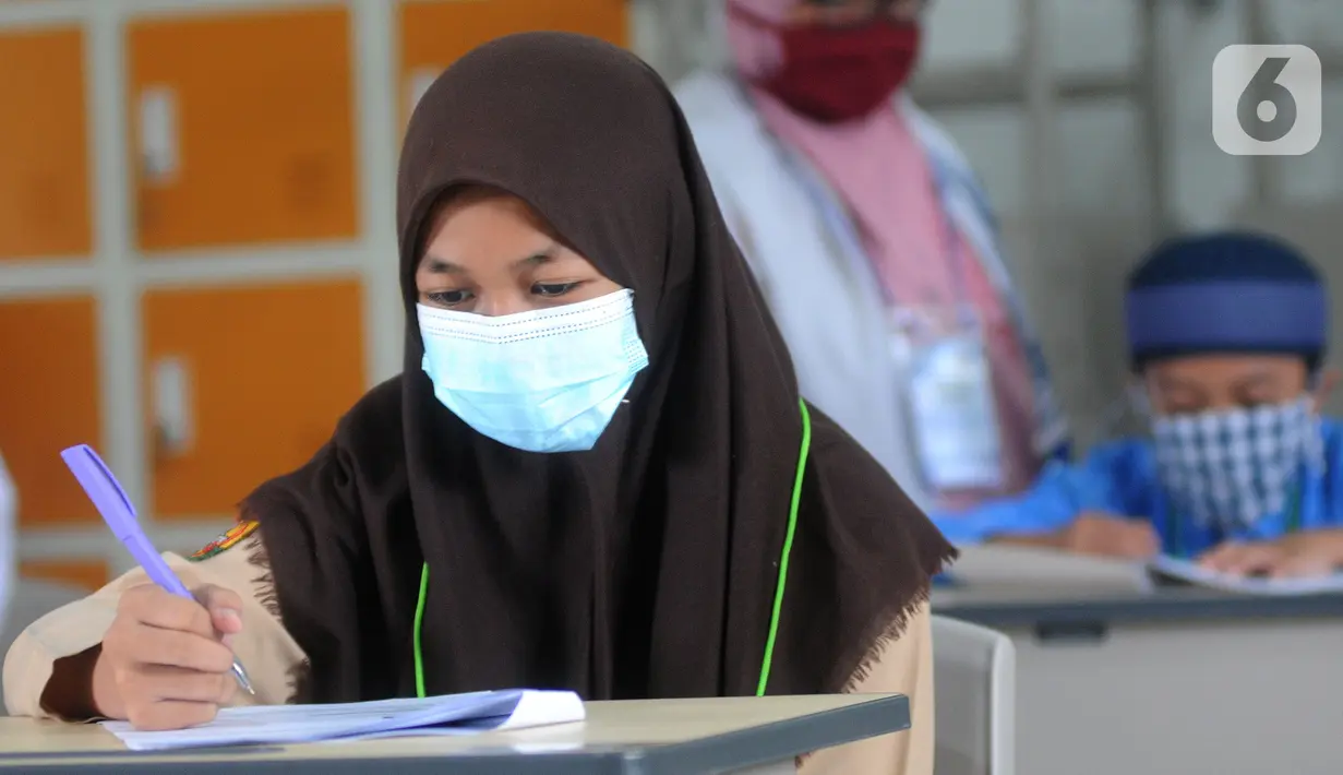 Seorang murid perwakilan sekolah mengerjakan soal saat kegiatan Kompetisi Sains Nasional (KSN) seleksi Tingkat SD/ MI Kecamatan Cinere  mata pelajaran IPA di SDIT MU, Depok, Jawa Barat, Sabtu (6/3/2021). Sebelumnya dilaksanakan secara virtual akibat pandemi covid-19. (merdeka.com/Arie Basuki)