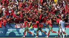 Para pemain Maroko merayakan gol yang dicetak oleh Soufiane Rahimi ke gawang Argentina pada laga pertama grup B Olimpiade 2024 di stadion Geoffroy-Guichard, Rabu (24/7/2024). Argentina tumbang dengan skor 1-2. (AP Photo/Silvia Izquierdo)