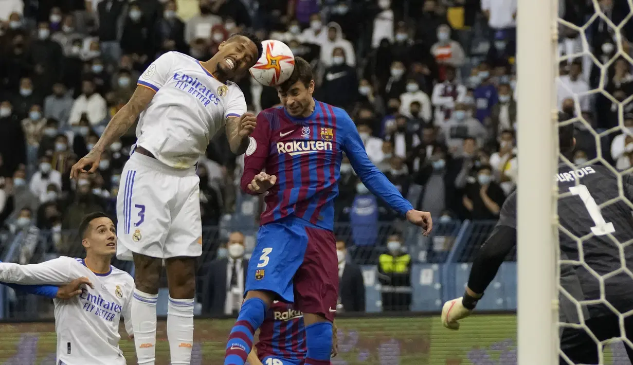 Bek Real Madrid, Eder Militao berebut bola udara dengan bek Barcelona, Gerard Pique pada pada semifinal Piala Super Spanyol di Stadion King Fahd di Riyadh, Arab Saudi, Kamis (13/1/2022). Real Madrid akan bertemu pemenang Atletico Madrid vs Athletic Bilbao di Final. (AP Photo/Hassan Ammar)