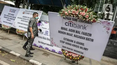Security menurunkan karangan bunga di depan Kantor Adaro, Jakarta, Senin (3/5/2021). Gerakan Extinction Rebellion Indonesia mengirim karangan bunga yang ditujukan kepada sindikasi perbankan pemberi pinjaman dan Adaro. (Liputan6.com/Faizal Fanani)