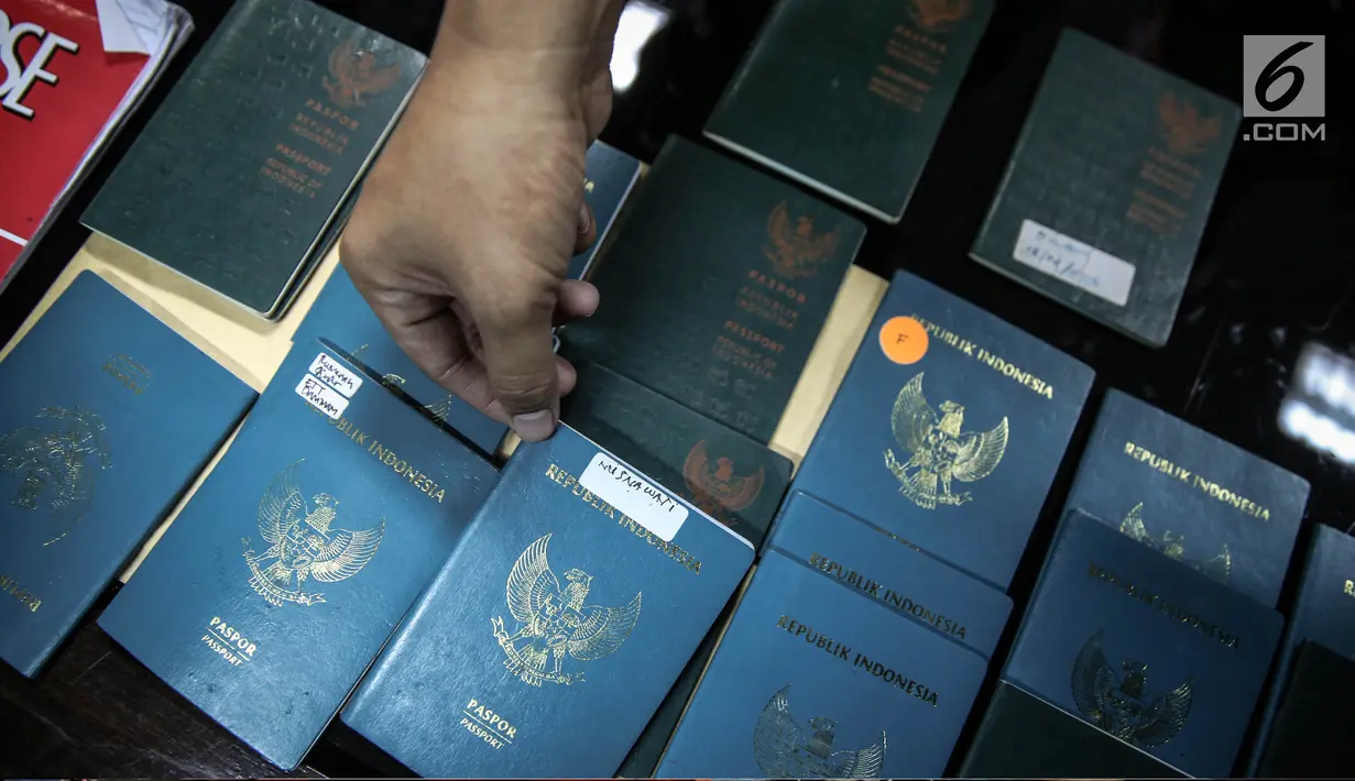 Barang bukti berupa paspor yang diamankan pada kasus perdagangan orang ke Suriah dan Abu Dhabi saat rilis di Bareskrim Mabes Polri, Kamis (10/8). Selain itu, ada juga barang bukti seperti 10 visa Timur Tengah dan buku tabungan (Liputan6.com/Faizal Fanani)