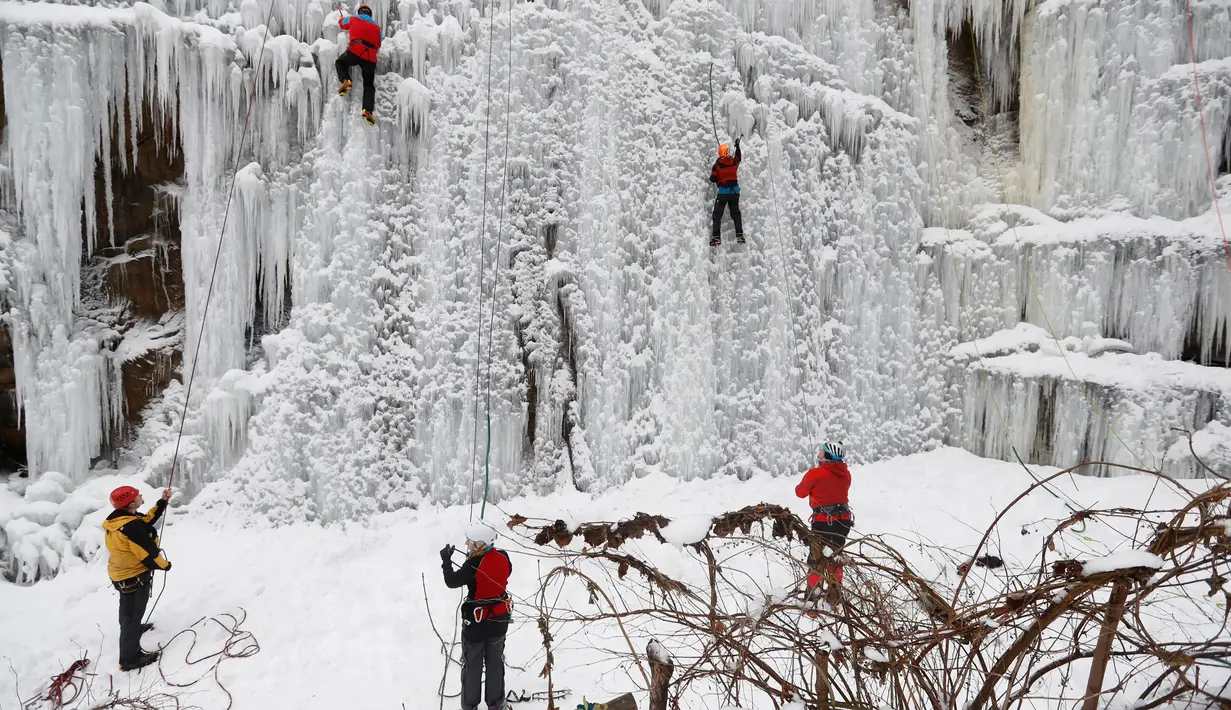Orang-orang memanjat dinding es buatan di kota Liberec, Republik Ceko, Minggu (27/1). Meski buatan, tidak sembarang orang bisa menaklukkan tebing es tersebut. (AP Photo/Petr David Josek)