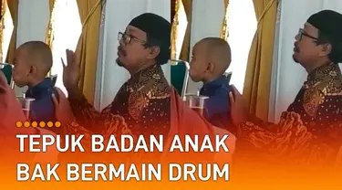 Ia tampak menepuk badan dan kepala anaknya, bergaya mengikuti irama drum.