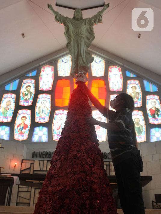 Umat Katolik menghias pohon Natal di Gereja Santo Barnabas, Tangerang Selatan, Banten, Kamis (23/12/2021). Sejumlah gereja di Indonesia mulai melakukan persiapan dan pemasangan dekorasi untuk menyambut misa dan perayaan Natal 2021. (merdeka.com/Arie Basuki)