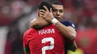 Penyerang #10 Prancis Kylian Mbappe memeluk bek Maroko #02 Achraf Hakimi pada akhir babak semifinal Piala Dunia 2022 di Al Bayt Stadium, Kamis (15/12/2022) dini hari WIB. Posisi bermain mereka membuat Mbappe dan Hakimi harus head to head di Al Bayt Stadium. (AP Photo/Manu Fernandez)