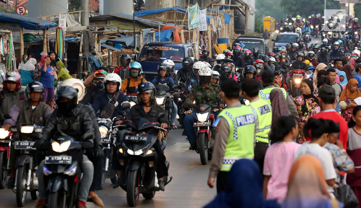 Polisi mengatur arus lalu lintas pemudik sepeda motor di Jalur Pantura Indramayu - Cirebon, Jawa Barat, Jumat (23/6). Pemudik bersepeda motor mendominasi jalur Pantura wilayah Kabupaten Indaramayu, memasuki H-2 Lebaran 2017. (Liputan6.com/Johan Tallo)