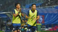 Penggawa Arema FC, Evan Dimas (kanan) bersama Dedik Setiawan mengenakan rompi pemain cadangan. (Bola.com/Iwan Setiawan)