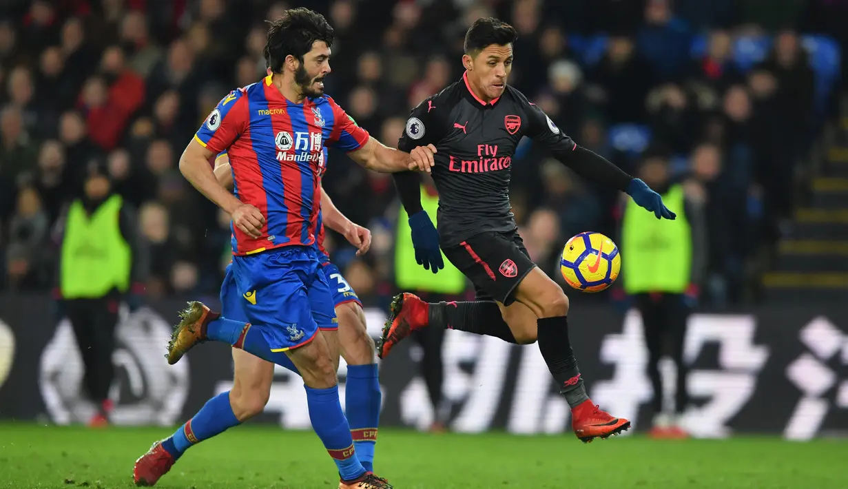 Striker Arsenal Alexis Sanchez membawa bola berusaha melewati pemain Crystal Palace saat pertandingan Liga Inggris di stadion Selhurst Park di London (28/12). Arsenal berhasil menang 2-3 atas Crystal Palace. (AFP Photo/Ben Stansall)
