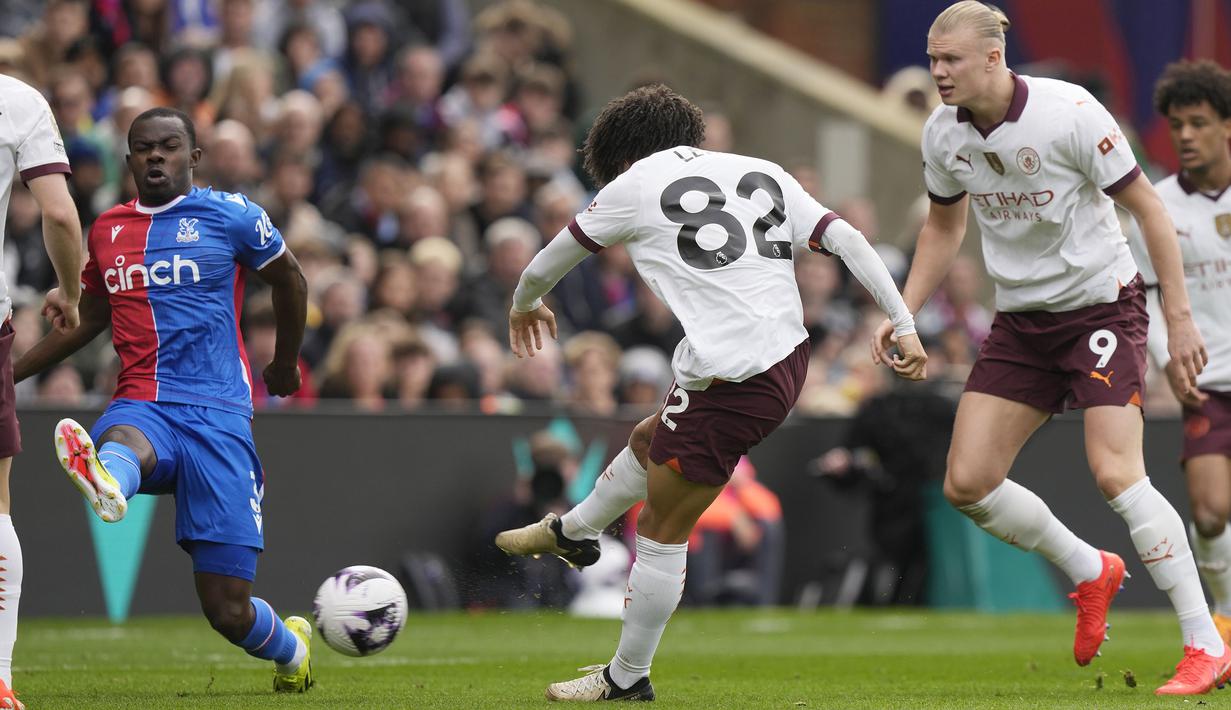 Bek Manchester City, Rico Lewis (tengah) melepaskan tendangan yang menghasilkan gol kedua timnya ke gawang Crystal Palace pada laga pekan ke-32 Premier League 2023/2024 di Selhurst Park stadium, London, Sabtu (6/4/2024). (AP Photo/Frank Augstein)