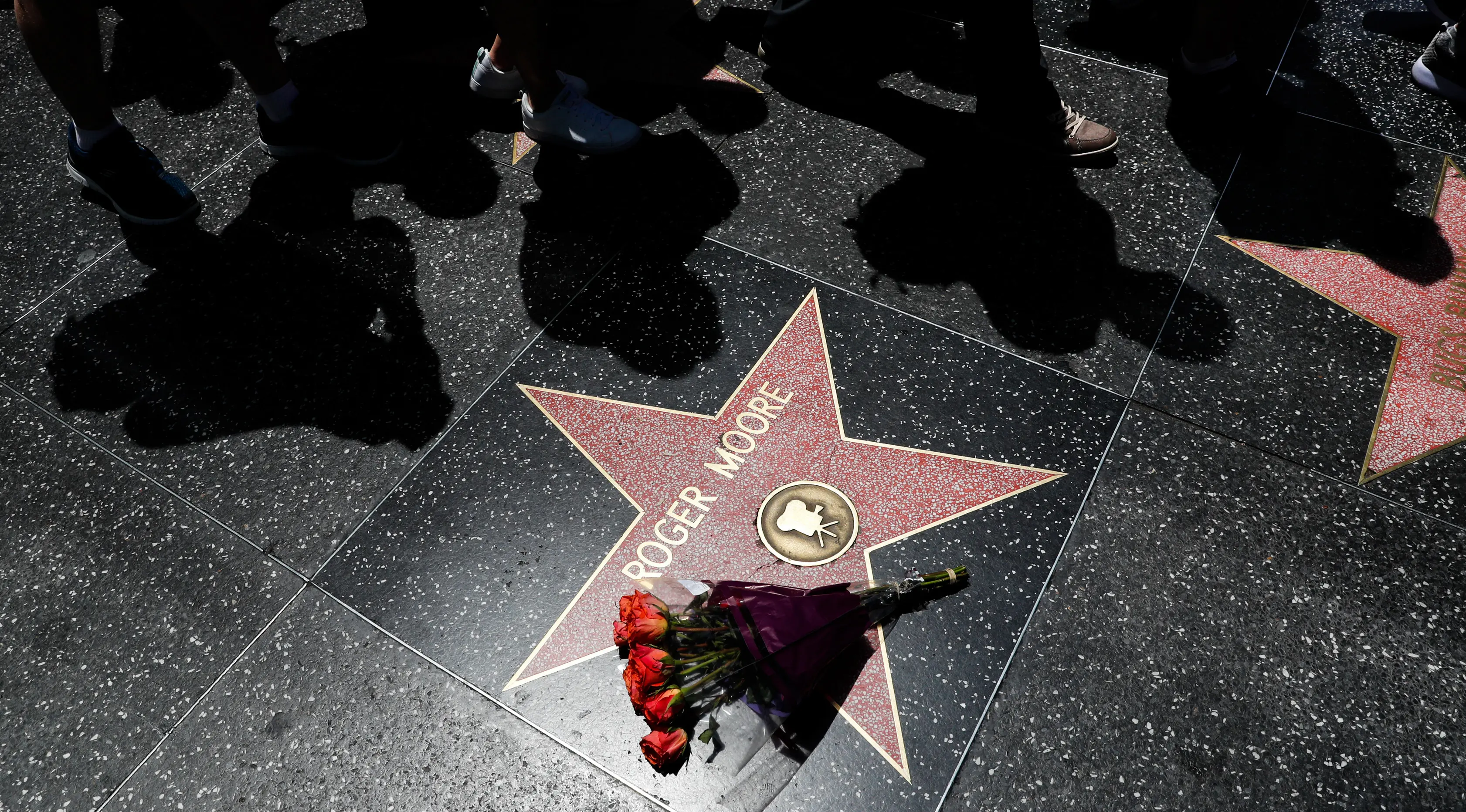 Sebuah buket bunga diletakkan di atas bintang Walk of Fame milik aktor Inggris, Roger Moore, di Hollywood, Los Angeles, Selasa (23/5). Aktor yang namanya dikenal karena memerankan James Bond itu meninggal dunia pada usia 89 tahun. (AP Photo/Jae C. Hong)