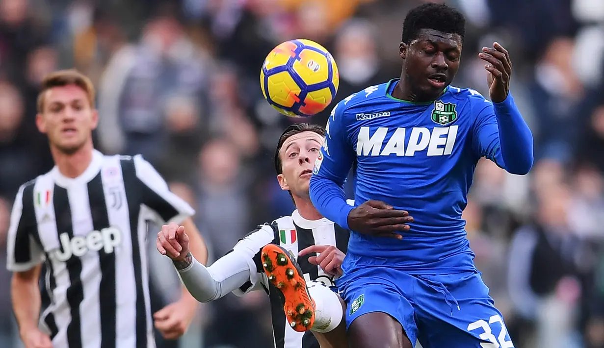 Duel pemain Juventus, Federico Bernardeschi (tengah) dengan pemain Sassuolo, Joseph Duncan (kanan) pada lanjutan Serie A di Allianz Stadium, Turin (4/2/2018). Juventus menang 7-0. (AFP/Marco Bertorello)