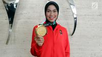 Atlet Taekwondo Defia Rosmaniar menunjukkan medali emas Asian Games 2018 saat berkunjung ke SCTV, Senayan City, Jakarta, Senin (20/8). Kunjungannya tersebut untuk melakukan wawancara. (Liputan6.com/Johan Tallo)